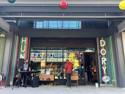 Hunky Dory storefront with a producer playing outside